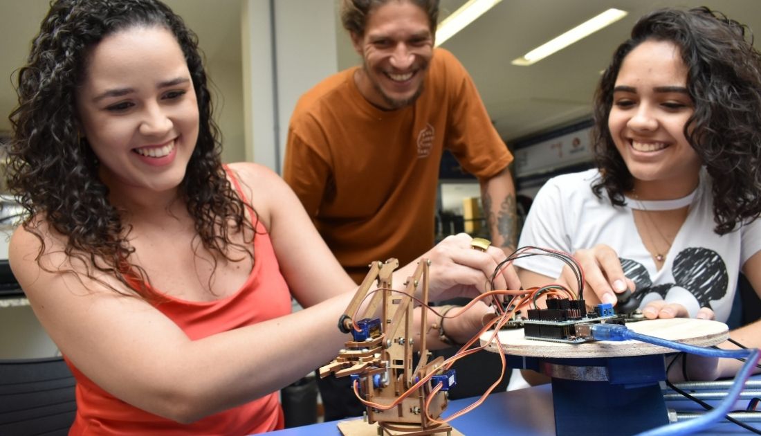 Alunos de Engenharia no Espaço Maker com robo.